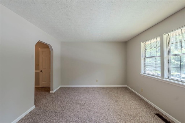 2247 Cherokee Valley Dr, Lithonia, GA 30058 - spare room featuring carpet flooring, a textured ceiling, and arched walkways