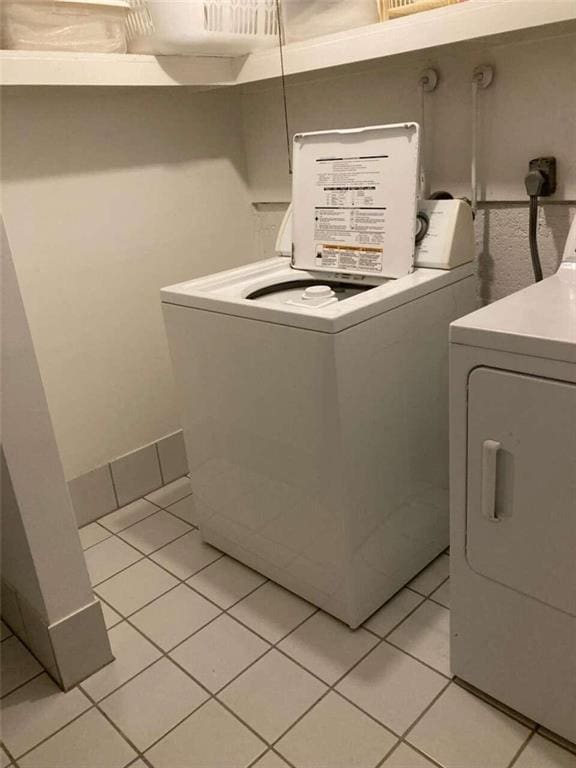 washroom featuring laundry area, independent washer and dryer, and light tile patterned flooring
