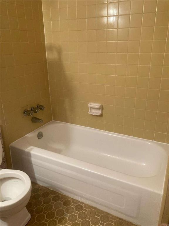bathroom with toilet and shower / bathing tub combination