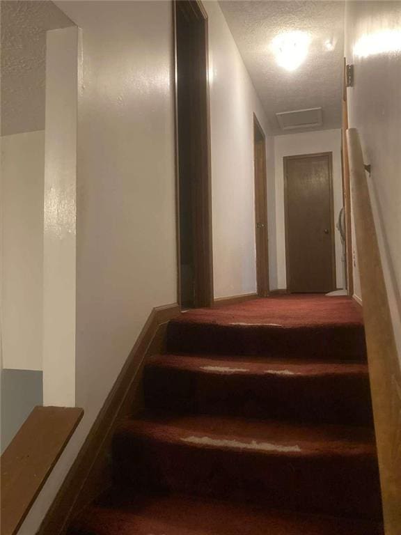 staircase with a textured ceiling