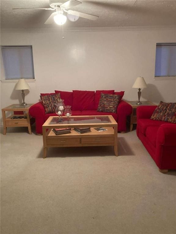 carpeted living area with crown molding, a textured ceiling, and ceiling fan