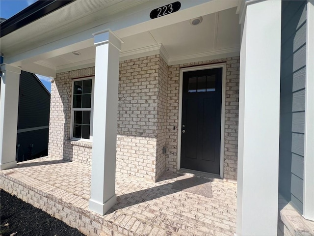 view of exterior entry with a porch