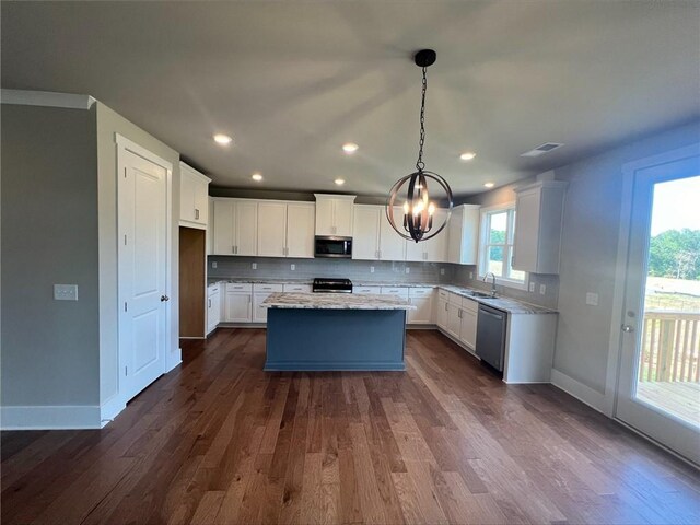 kitchen with decorative light fixtures, dark hardwood / wood-style flooring, a center island, appliances with stainless steel finishes, and white cabinets