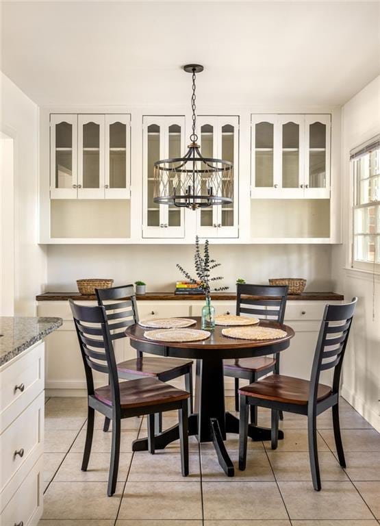 tiled dining space featuring an inviting chandelier