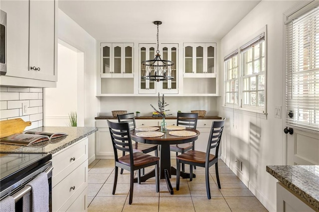 tiled dining area featuring a chandelier