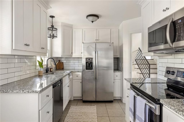 kitchen with sink, stainless steel appliances, hanging light fixtures, and white cabinets