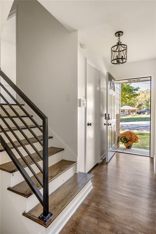 entryway with a notable chandelier and dark hardwood / wood-style flooring