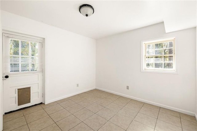 unfurnished room with light tile patterned floors and a healthy amount of sunlight