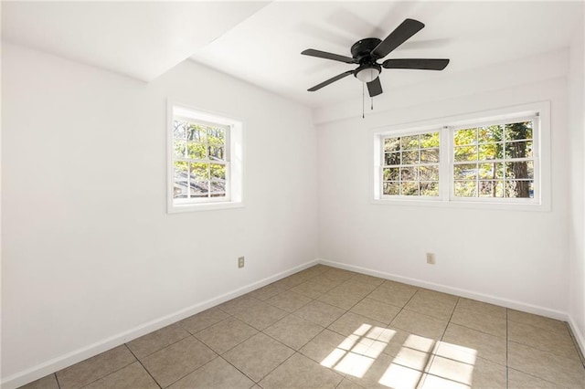 tiled empty room featuring a wealth of natural light and ceiling fan