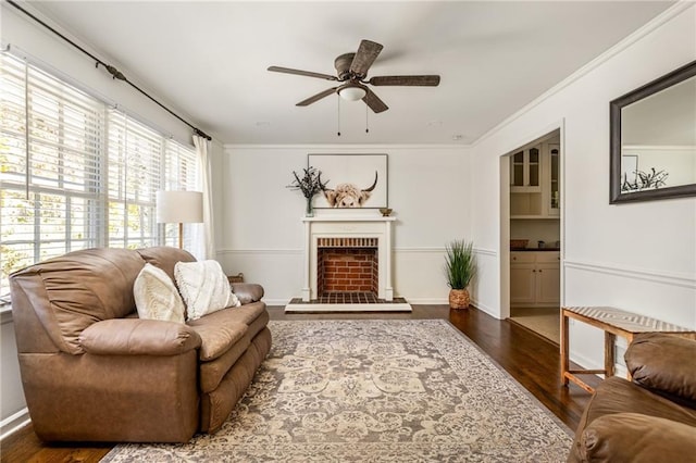 living room featuring crown molding, a brick fireplace, ceiling fan, and dark hardwood / wood-style flooring