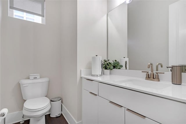 bathroom featuring toilet, vanity, and wood-type flooring