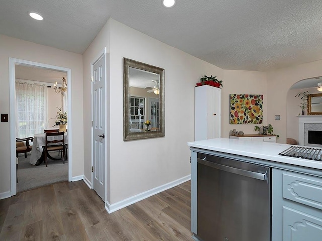 4601 Gann Xing SW, Smyrna, GA 30082 - kitchen featuring dishwasher, dark wood-type flooring, light countertops, arched walkways, and a textured ceiling
