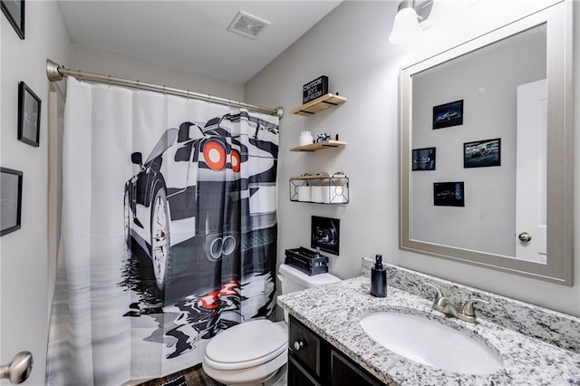 bathroom featuring toilet, vanity, and curtained shower