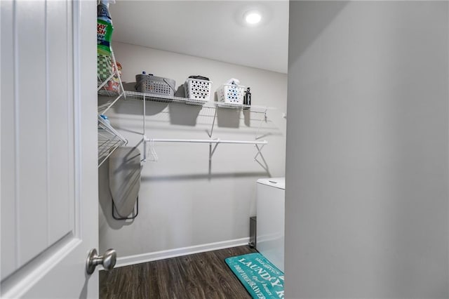 clothes washing area featuring wood finished floors and baseboards