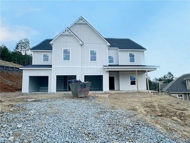 rear view of house featuring a garage and covered porch