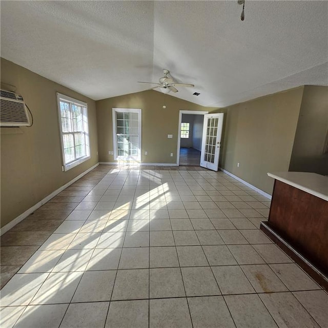 unfurnished living room featuring lofted ceiling, light tile patterned floors, a textured ceiling, and ceiling fan