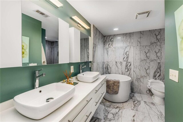 951 Glenwood Ave SE Unit 1805, Atlanta, GA 30316 - bathroom with tile walls, marble finish flooring, a freestanding tub, toilet, and double vanity