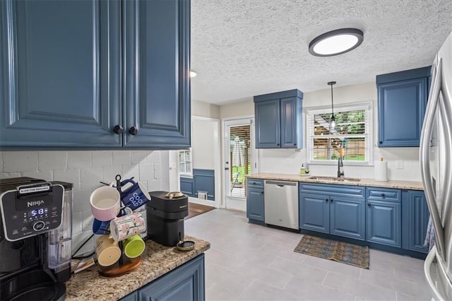 110 Village Ct, Woodstock, GA 30188 - kitchen featuring stainless steel appliances, blue cabinets, decorative light fixtures, light stone counters, and a textured ceiling