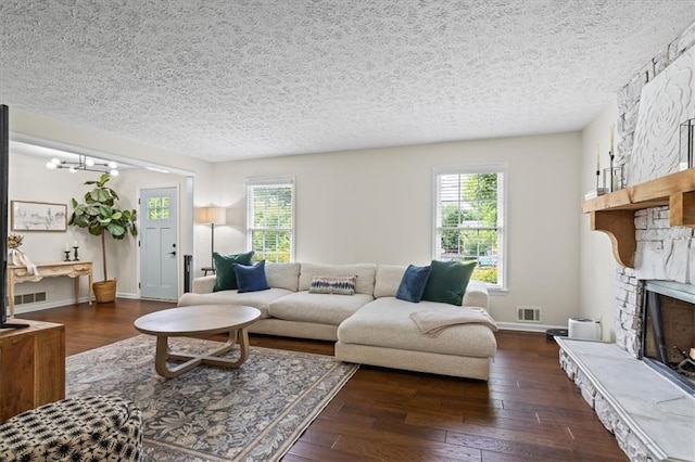 110 Village Ct, Woodstock, GA 30188 - living room with plenty of natural light, a textured ceiling, a stone fireplace, and wood finished floors