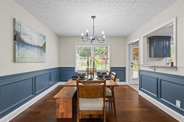 110 Village Ct, Woodstock, GA 30188 - dining space featuring a chandelier, a textured ceiling, dark wood-style floors, wainscoting, and a decorative wall