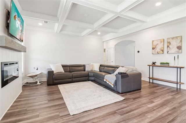 66 Cottontail Ln, Loganville, GA 30052 - living area featuring arched walkways, a large fireplace, wood finished floors, beamed ceiling, and recessed lighting