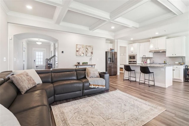 66 Cottontail Ln, Loganville, GA 30052 - living area featuring arched walkways, beamed ceiling, wood finished floors, coffered ceiling, and recessed lighting