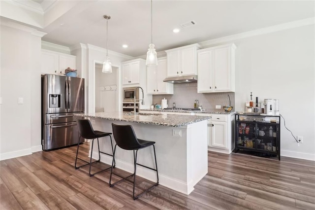 66 Cottontail Ln, Loganville, GA 30052 - kitchen with stainless steel appliances, under cabinet range hood, crown molding, a sink, and dark wood-style flooring