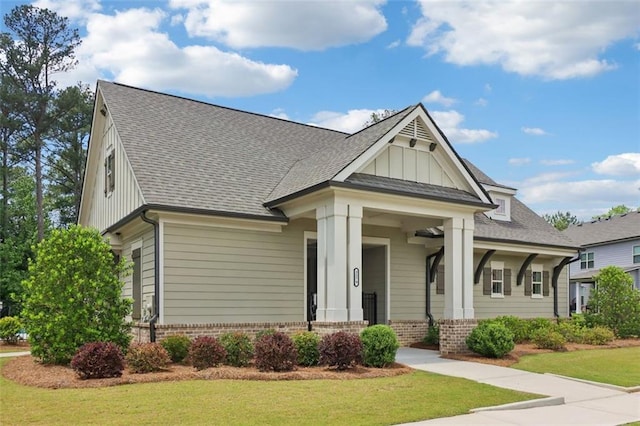 66 Cottontail Ln, Loganville, GA 30052 - craftsman-style house with board and batten siding, brick siding, a front yard, and a shingled roof