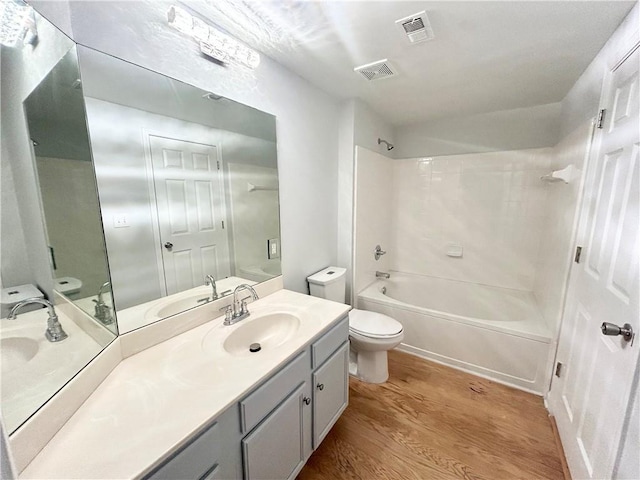 full bathroom with vanity, hardwood / wood-style floors,  shower combination, and toilet