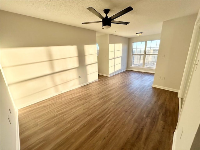 spare room featuring ceiling fan, dark wood-type flooring, and a textured ceiling