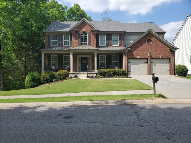 view of front of house featuring an attached garage, a front yard, brick siding, and driveway