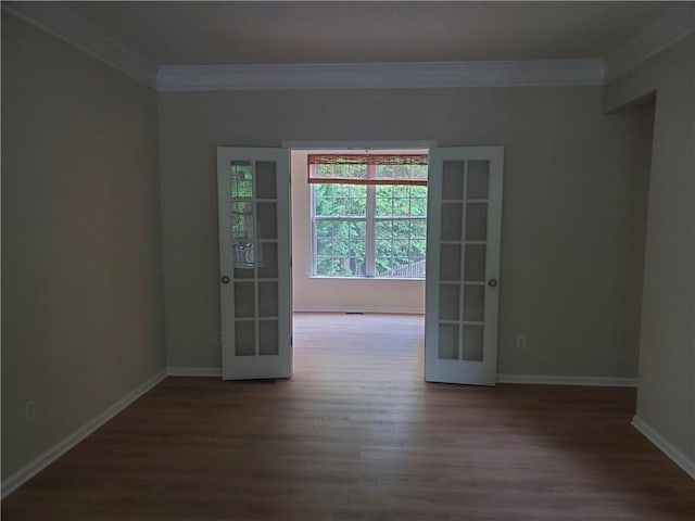 empty room featuring french doors, wood finished floors, baseboards, and ornamental molding