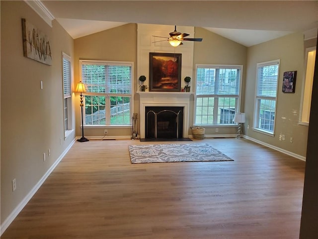 unfurnished living room with lofted ceiling, baseboards, a fireplace with flush hearth, and wood finished floors