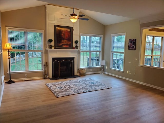 unfurnished living room featuring vaulted ceiling, baseboards, a ceiling fan, and wood finished floors