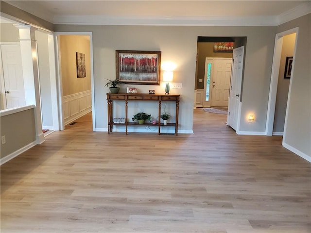 interior space with wood finished floors, baseboards, and ornamental molding