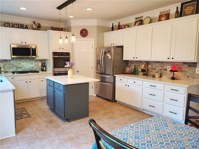 kitchen with hanging light fixtures, white cabinets, backsplash, appliances with stainless steel finishes, and ornamental molding