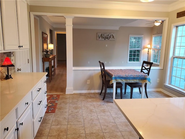 dining space featuring a ceiling fan, baseboards, a healthy amount of sunlight, and crown molding