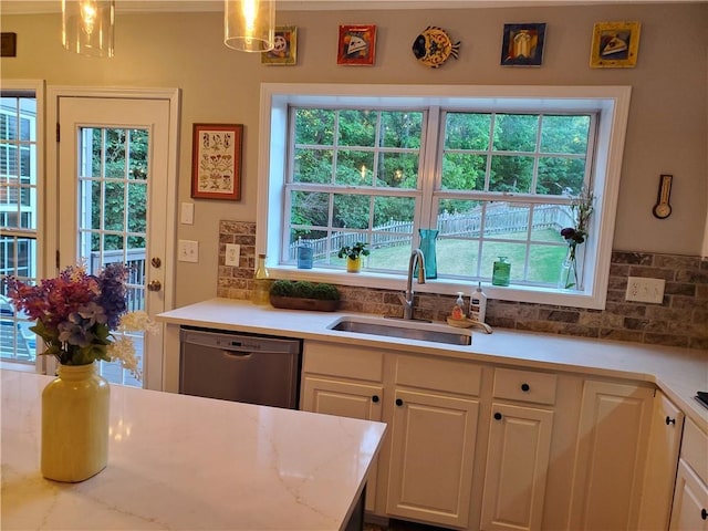 kitchen featuring a sink, backsplash, plenty of natural light, and dishwasher