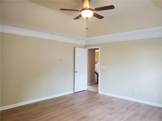 unfurnished room featuring crown molding, light wood-style flooring, baseboards, and a ceiling fan