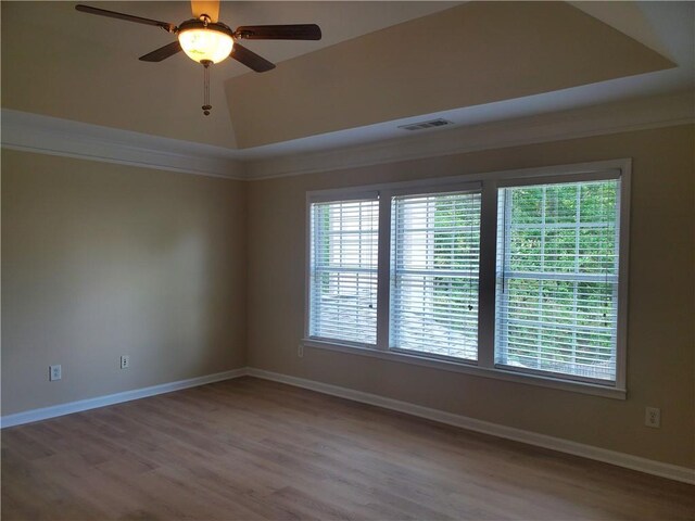 spare room featuring a wealth of natural light, visible vents, and wood finished floors