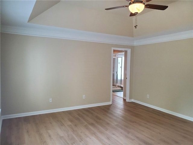 spare room with a ceiling fan, baseboards, crown molding, and wood finished floors