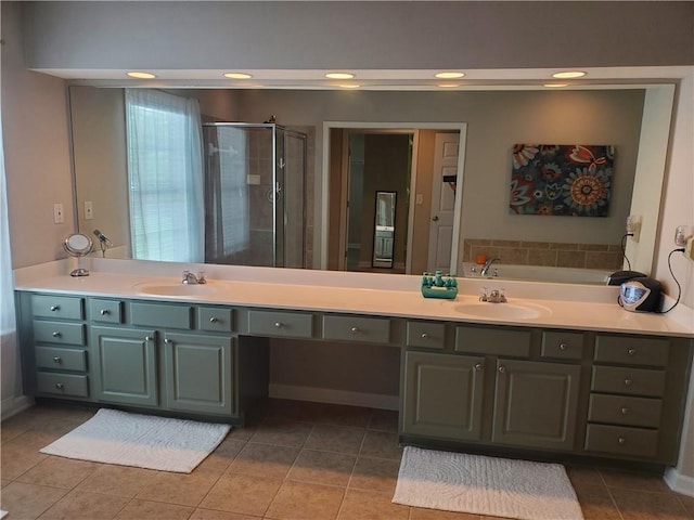 bathroom with a sink, double vanity, a stall shower, and tile patterned floors
