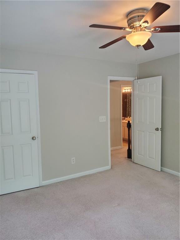 interior space with light carpet, baseboards, and a ceiling fan
