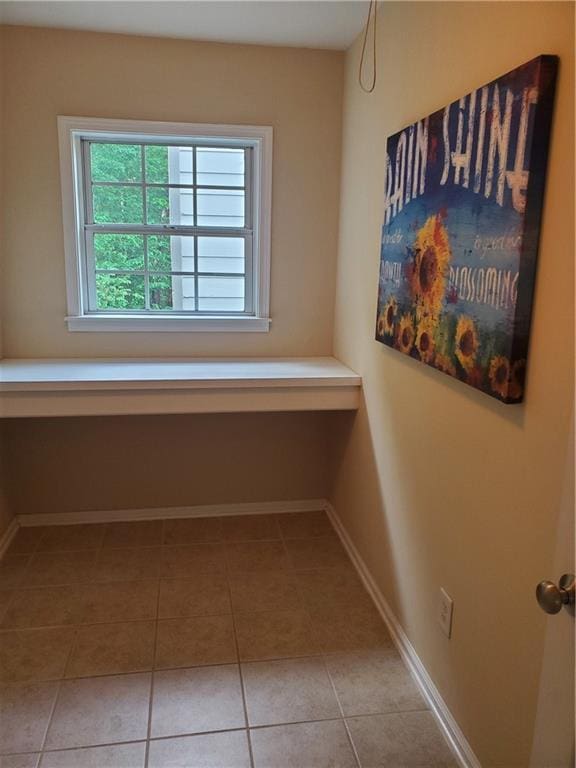 hallway with baseboards and light tile patterned flooring
