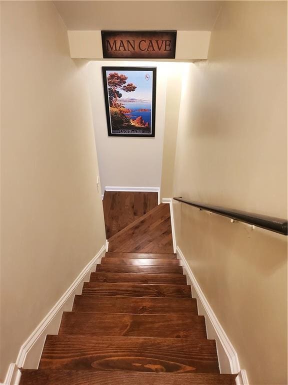 stairway featuring baseboards and wood finished floors