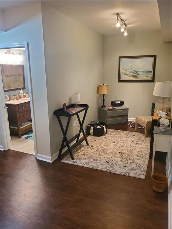 interior space featuring track lighting, wood finished floors, and baseboards