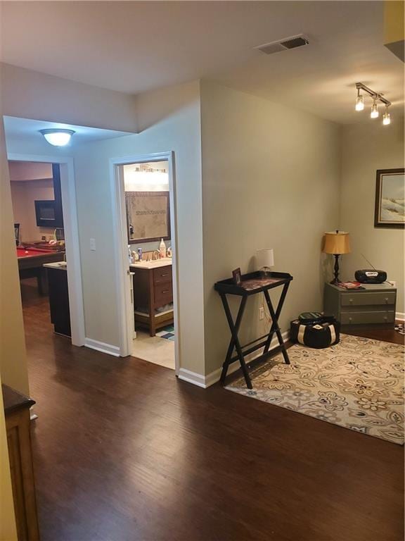 interior space with baseboards, visible vents, and dark wood finished floors