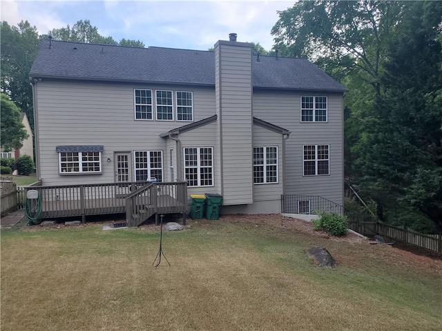 back of house with a yard, a chimney, a wooden deck, and fence