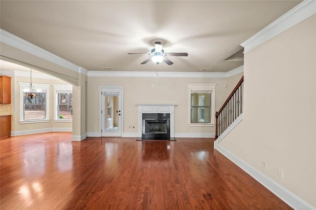 unfurnished living room featuring hardwood / wood-style flooring, crown molding, and ceiling fan with notable chandelier