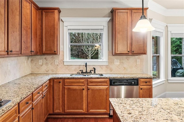 kitchen with sink, stainless steel dishwasher, ornamental molding, pendant lighting, and light stone countertops